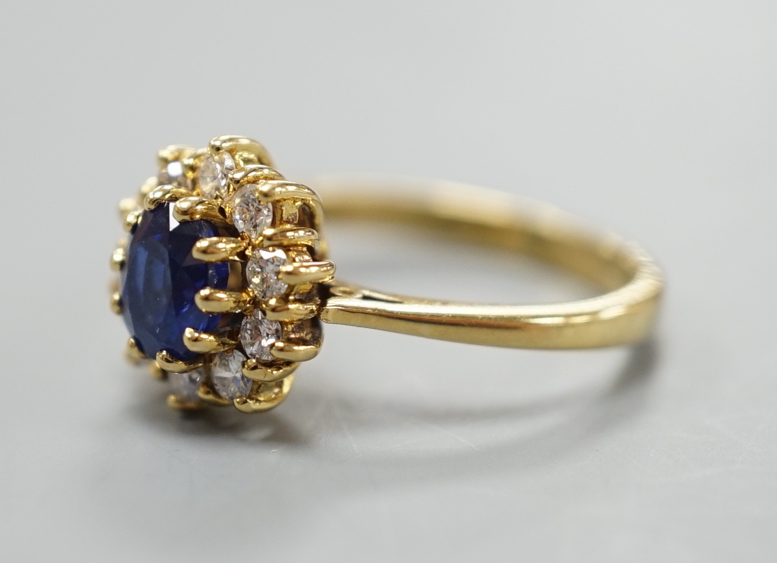 A modern 18ct gold, sapphire and diamond set oval cluster ring, size L, gross weight 3.8 grams